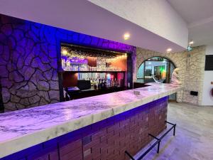 a bar with a stone wall and purple lighting at Han Dalyan Hotel in Dalyan