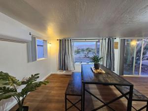 a living room with a wooden table and windows at Stargaze Grand Canyon in Meadview