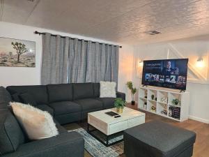 a living room with a couch and a tv at Stargaze Grand Canyon in Meadview