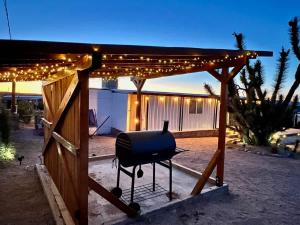 a grill under a pergola with lights on it at Stargaze Grand Canyon in Meadview +38 photos