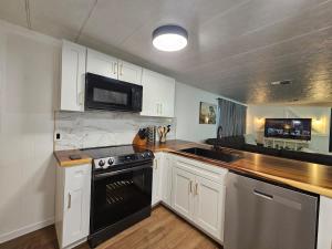 a kitchen with white cabinets and a black stove top oven at Stargaze Grand Canyon in Meadview