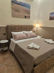 a bedroom with a bed with two towels on it at Corte26 in Nocera Inferiore