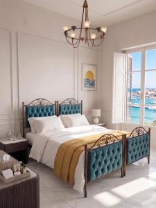 a bedroom with a large bed and a chandelier at Amare boutique Hotel in Salerno Airport - Aeroporto di Salerno