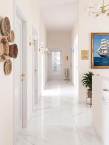 a hallway with white floors and a white hallway with a sailboat at Amare boutique Hotel in Salerno Airport - Aeroporto di Salerno