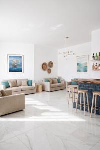 a white living room with couches and a table at Amare boutique Hotel in Salerno Airport - Aeroporto di Salerno
