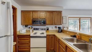 a kitchen with wooden cabinets and a white stove top oven at Lake Town Access Deck Pool Wood Stove in McCall