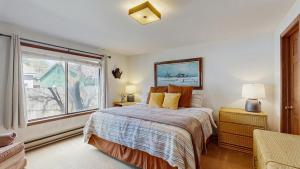 a bedroom with a bed and a large window at Lake Town Access Deck Pool Wood Stove in McCall