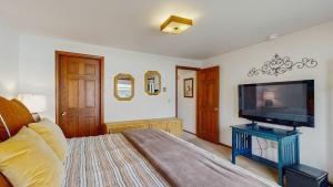 a bedroom with a bed and a flat screen tv at Lake Town Access Deck Pool Wood Stove in McCall +17 photos