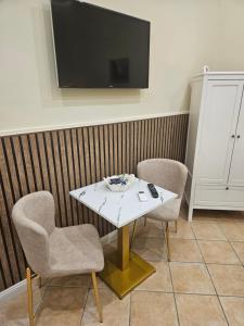 a room with a table and two chairs and a tv at Corte26 in Nocera Inferiore