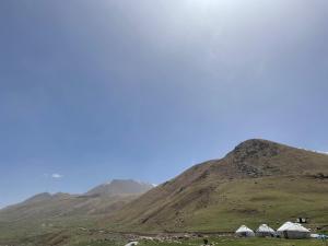 tents on a hill with mountains in the background at Zhailoo Guest House Kochkor in Kochkorka