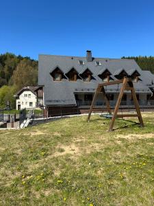 a large house with a playground in front of it at Chata Trojkámen in Nové Losiny