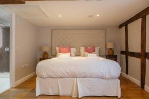 a bedroom with a large white bed with red pillows at Characterful Home Steps from Cathedral in Hereford