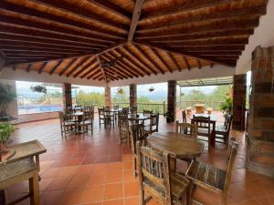 a restaurant with wooden tables and chairs and windows at Hotel Estaciones in Guatapé
