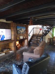 a living room with two couches and a fireplace at Samadi Hostel Uspallata in Uspallata