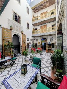 a courtyard with tables and chairs in a building at Riad Green House in Fez +45 photos