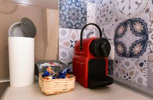a red suitcase sitting on a table next to a basket at Dimora Cavour 1810 in Civitavecchia