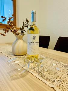 a bottle of wine sitting on a table with glasses at Ferienwohnung Alpenpfad in Elmen