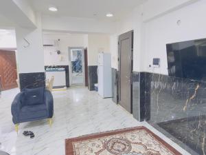 a living room with a blue chair and a door at مضيف الزهراء in Karbala