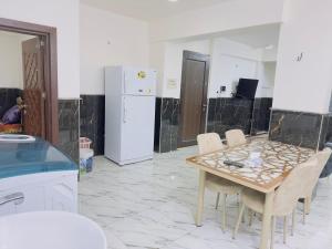a kitchen with a table and chairs and a refrigerator at مضيف الزهراء in Karbala