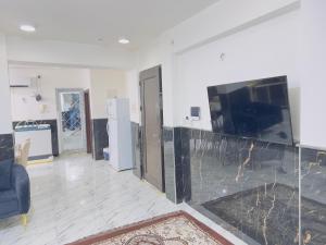 a living room with a tv and a blue couch at مضيف الزهراء in Karbala