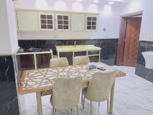 a kitchen with a wooden table and chairs at مضيف الزهراء in Karbala +4 photos