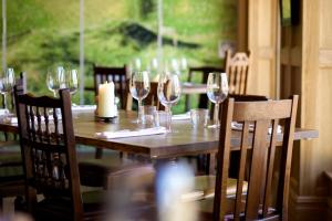 a wooden table with wine glasses on it at The Duchess of Cornwall in Dorchester