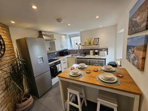 a kitchen with a table with plates on it at Railway Cottage, Liskeard in Liskeard