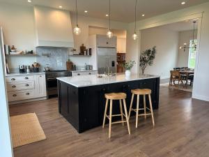 a kitchen with a large island with two bar stools at The Llama Lane House in Yakima