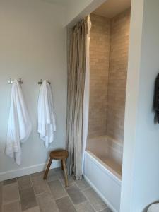 a bathroom with a tub and a shower curtain and a stool at The Llama Lane House in Yakima +43 photos