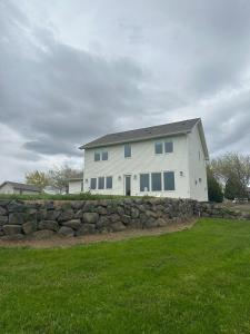 a white house with a stone wall in a yard at The Llama Lane House in Yakima