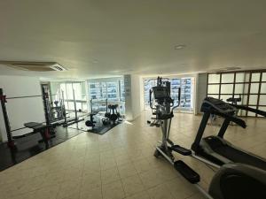 a gym with cardio equipment in a large room with windows at Apartamento Frente al Mar in Santa Marta