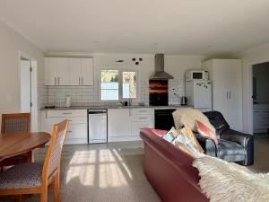 a living room with a couch and a kitchen at Diana's Place in Moeraki +17 photos