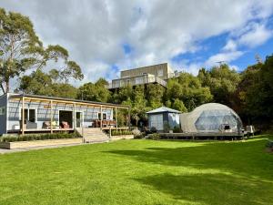 a greenhouse and a house in a yard at Diana's Place in Moeraki