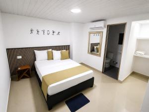 a bedroom with a large bed and a bathroom at Hotel Gama Cartagena in Cartagena de Indias