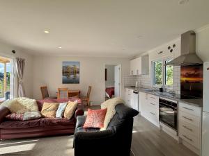 a living room with a couch and a kitchen at Diana's Place in Moeraki