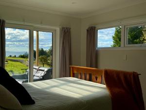 a bedroom with a bed and a large window at Diana's Place in Moeraki