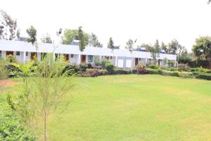 a house with a large lawn in front of it at Kithumulani Resort in Tiva