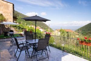 a patio with a table and chairs and an umbrella at zahira in Biassa
