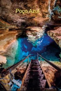 a staircase in a cave with blue water at Sítio com suítes e áreas de Lazer in Palmeiras