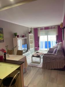 a bedroom with purple walls and a bed and a table at Relaxe La cala in Villajoyosa