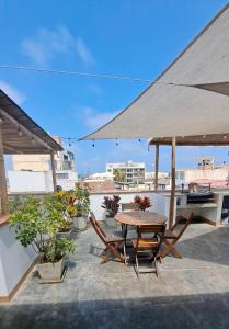 a patio with a table and chairs and an umbrella at VIVEMAR PUNTA HERMOSA - Beach House Lima - Perú in Punta Hermosa