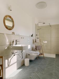 a bathroom with a sink and a toilet and a mirror at Naturhaus Havelland in Rathenow