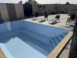 an empty swimming pool with chairs in a backyard at villa agadir in Glalcha +4 photos