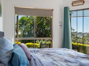 a bedroom with a bed and a large window at King bed studio seperate entry sauna pool garden view in Terranora