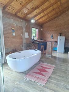 a large white tub in a room with a kitchen at Chalé Água Santa in São Thomé das Letras +18 photos
