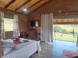 a bedroom with a bed with a teddy bear on it at Chalé Água Santa in São Thomé das Letras