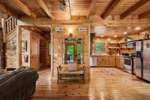 a log cabin kitchen with wooden walls and wooden floors at Scenic Serenity #75 by Venture Smoky Mountains in Sevierville