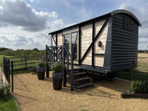 a black tiny house on display in a field at The 450 from Paddington in Bourton on Dunsmore