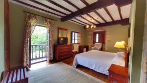 a bedroom with a bed and a tv and a window at Hotel Palación de Toñanes in Toñanes