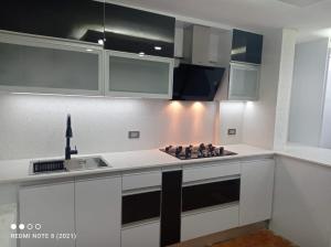 a kitchen with white cabinets and a stove top oven at Bloque 9y10 in Caracas